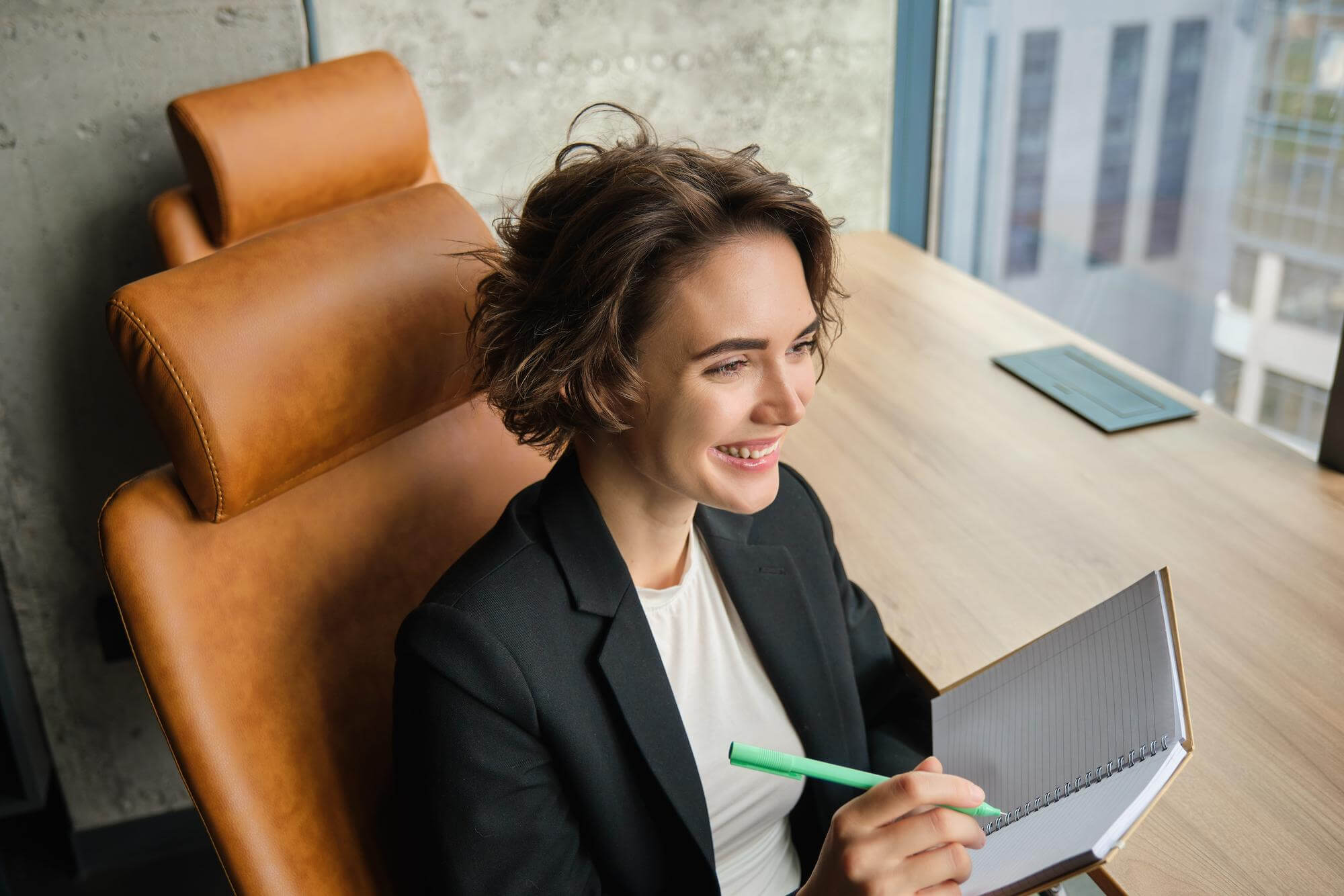 Woman smiling while holding a notebook