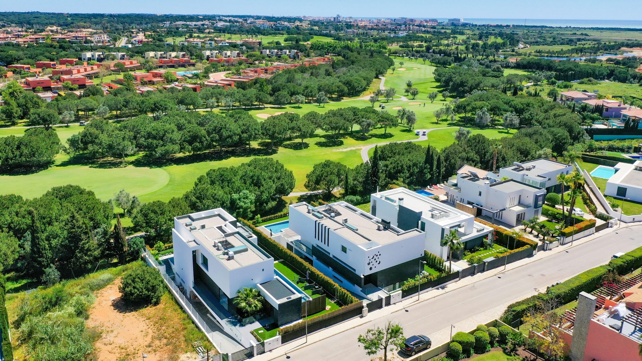 Aerial view of a luxury villa overlooking a championship golf course in Vilamoura, showcasing Central Algarve real estate.